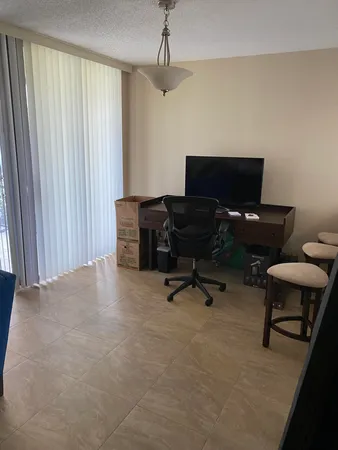 a dining room with furniture and a floor to ceiling window