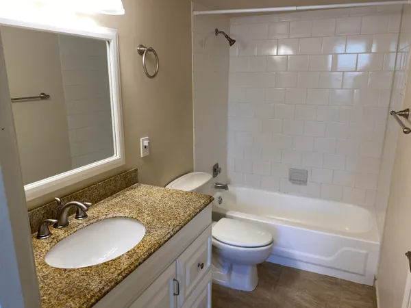 a white toilet sitting next to a bath tub