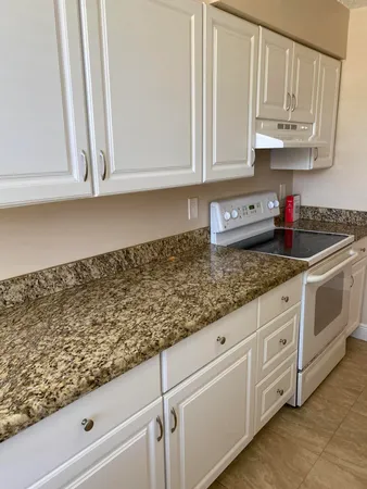 a kitchen with white cabinets and white appliances