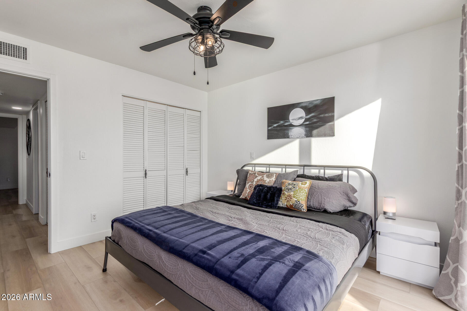 2529 North Miller Road Scottsdale, AZ 85257 - Photo 48 of 65 a bedroom with a large bed and a chandelier