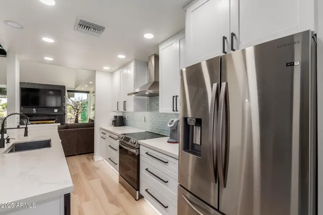 a kitchen with stainless steel appliances a refrigerator a stove a microwave a sink and a refrigerator