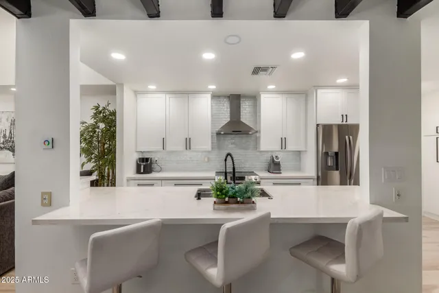 a kitchen with stainless steel appliances kitchen island granite countertop a sink and a refrigerator