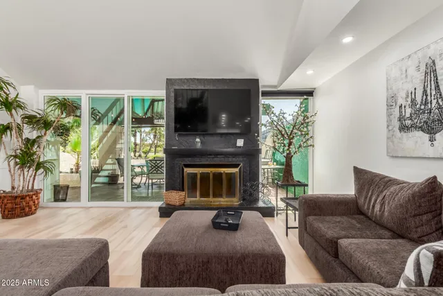 a living room with furniture a large window and a fireplace