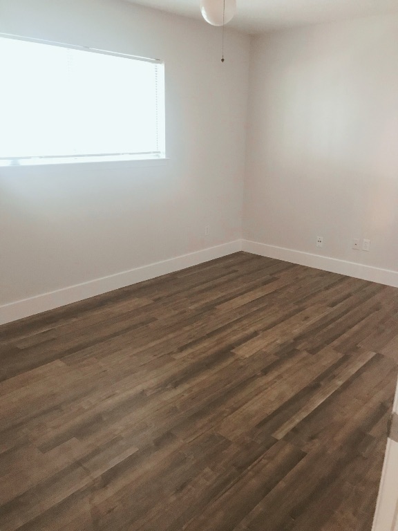 1415 Valleyridge Drive, Unit A Austin, TX 78704 - Photo 11 of 11 a view of an empty room with wooden floor and a window