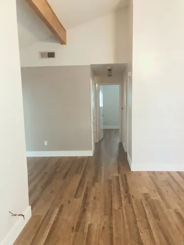 a view of a room with wooden floor
