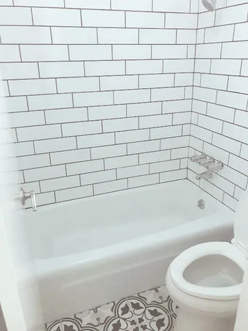 a bathroom with a white bathtub and a toilet