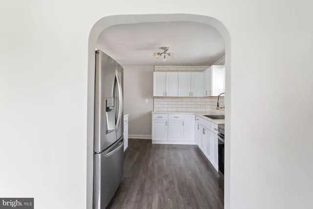 a kitchen with a sink a refrigerator and cabinets