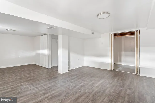 a view of an empty room with wooden floor