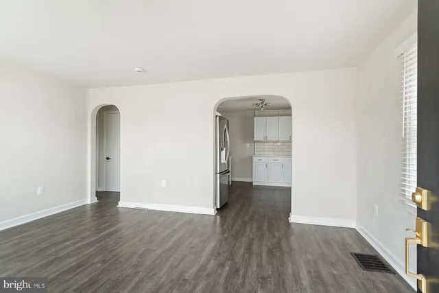 an empty room with wooden floor and mirror