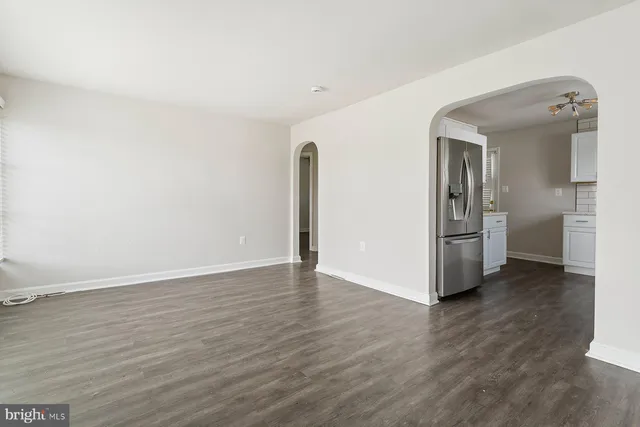 a view of an empty room with wooden floor and a cabinet