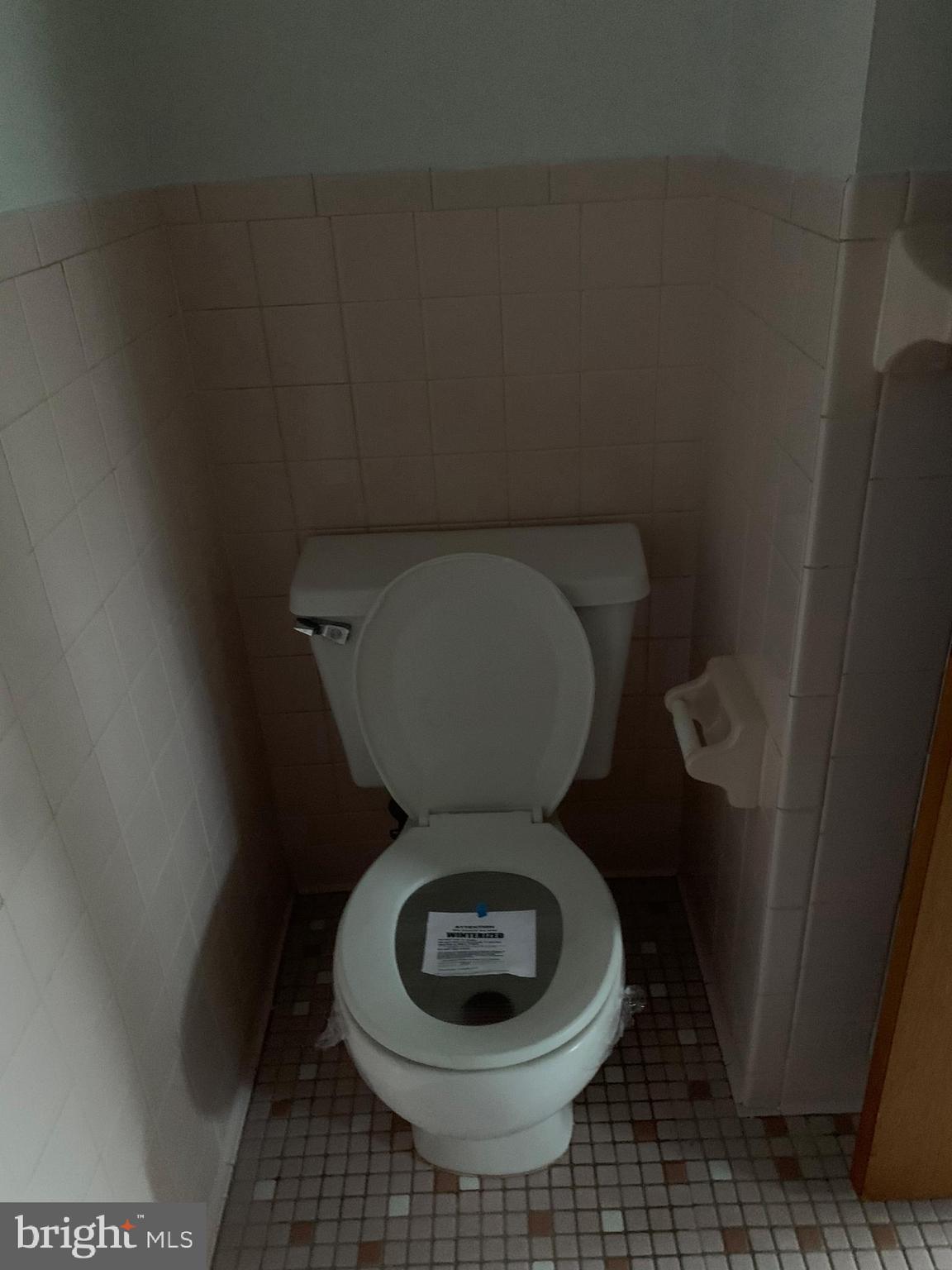 5866 Deale Churchton Road Deale, MD 20751 - Photo 11 of 26 a toilet sitting in a bathroom next to a wooden wall