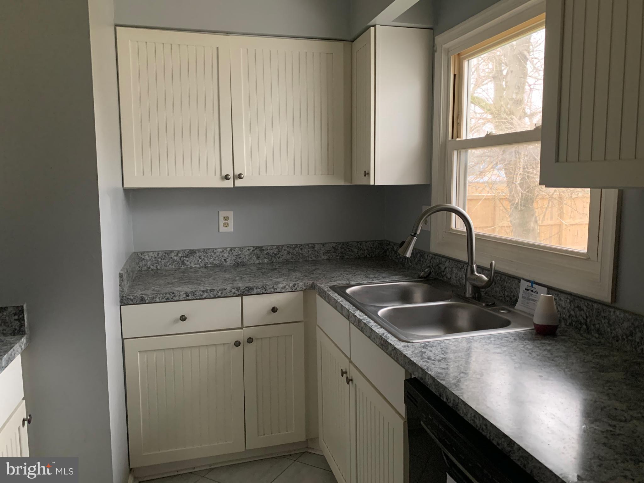 5866 Deale Churchton Road Deale, MD 20751 - Photo 14 of 26 a kitchen with granite countertop a sink a window and cabinets