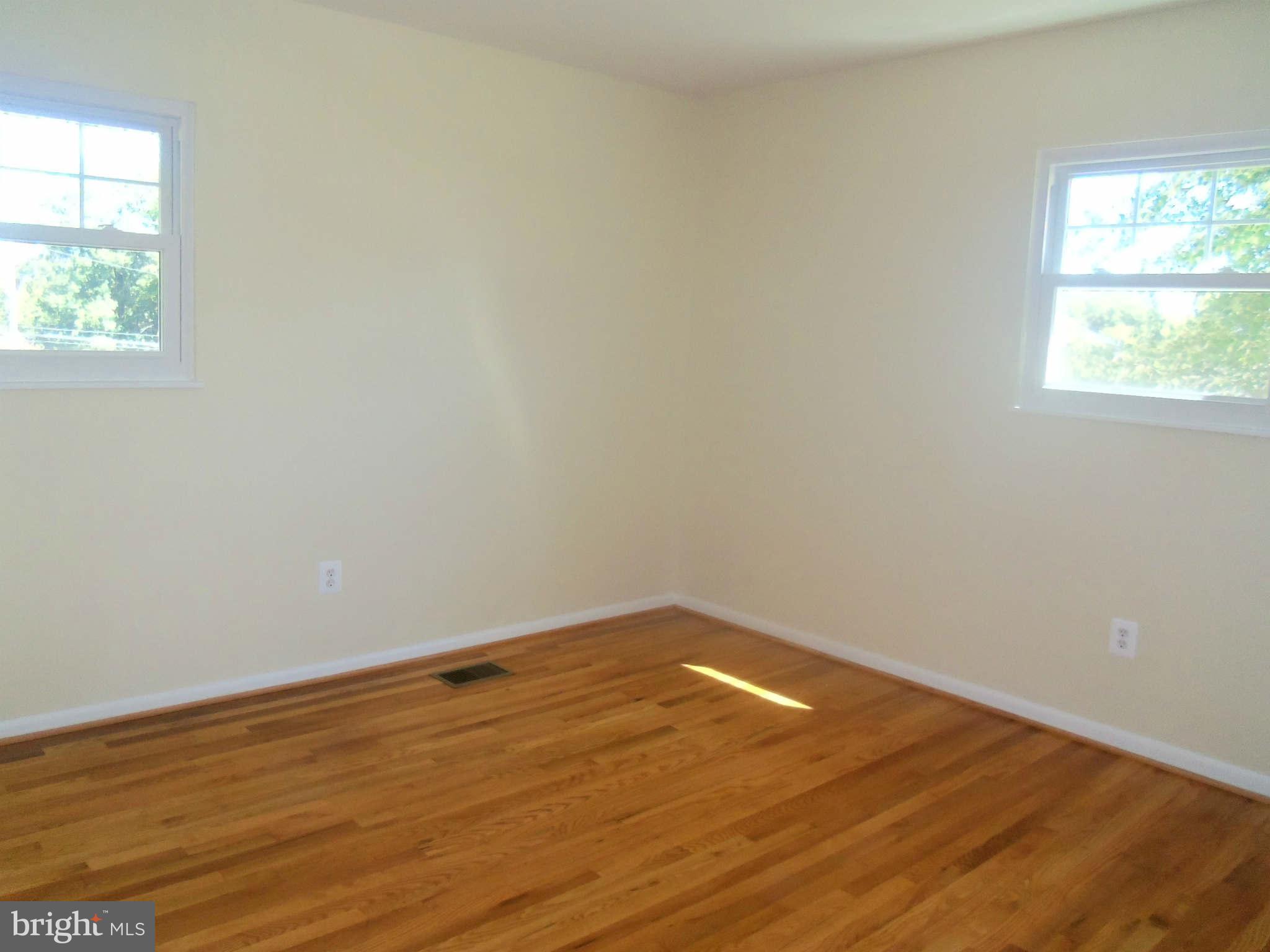 5704 Westgate Road Lanham, MD 20706 - Photo 11 of 25 an empty room with wooden floor and windows
