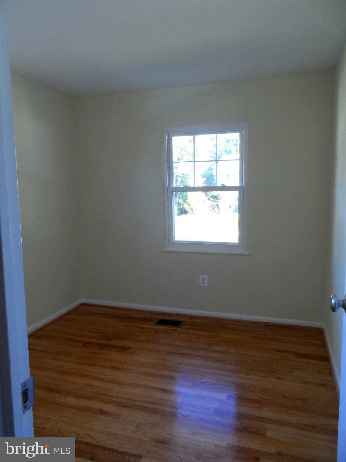 5704 Westgate Road Lanham, MD 20706 - Photo 13 of 25 an empty room with wooden floor and windows