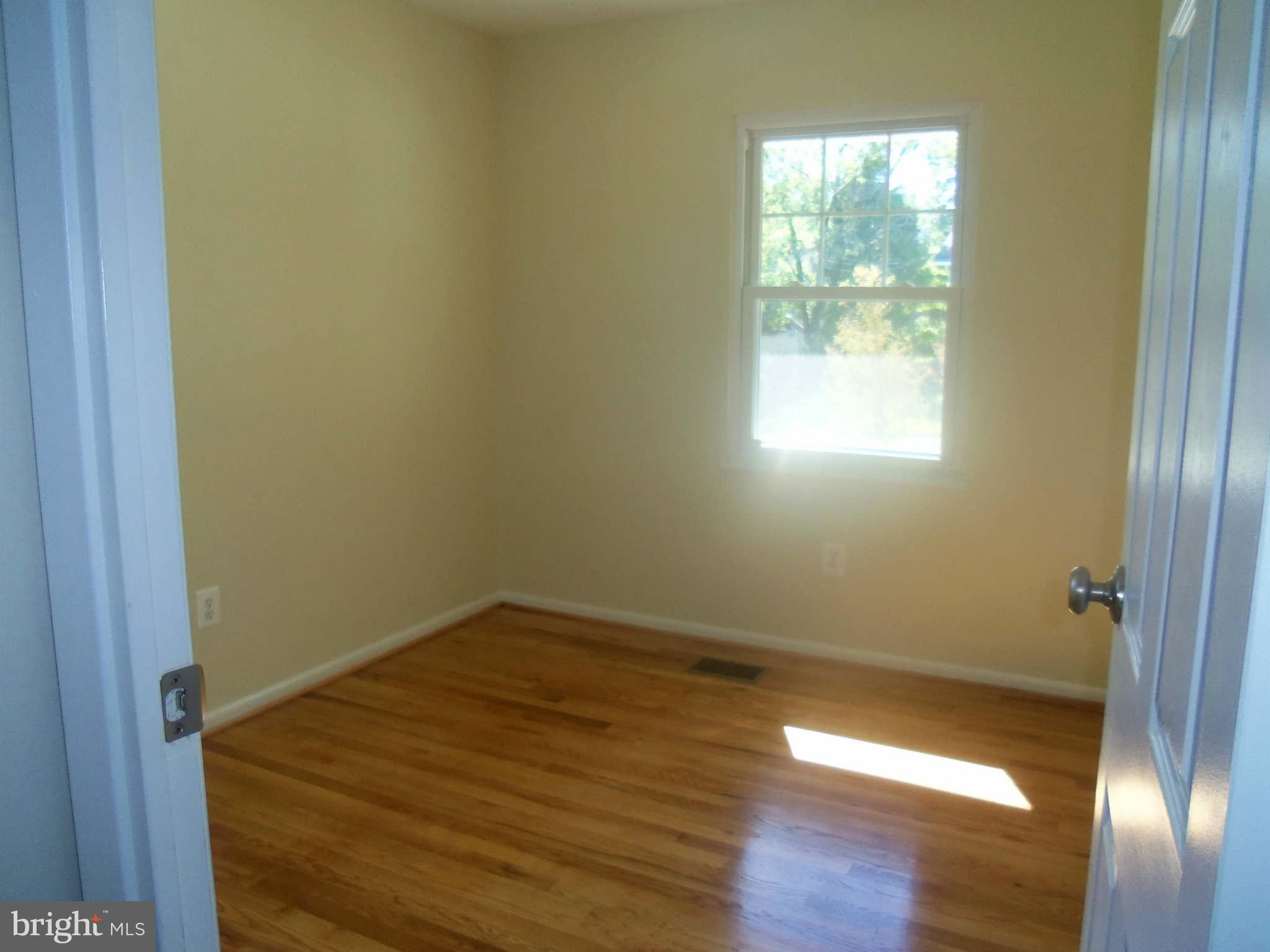 5704 Westgate Road Lanham, MD 20706 - Photo 14 of 25 a view of an empty room with wooden floor and a window
