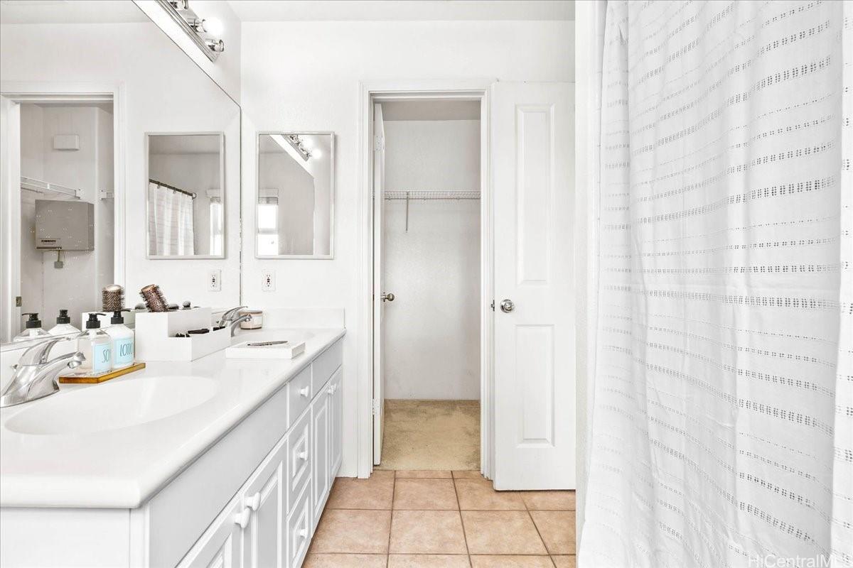 91-1121 Keoneula Boulevard, Unit L5 Ewa Beach, HI 96706 - Photo 13 of 20 a bathroom with a double vanity sink and a mirror