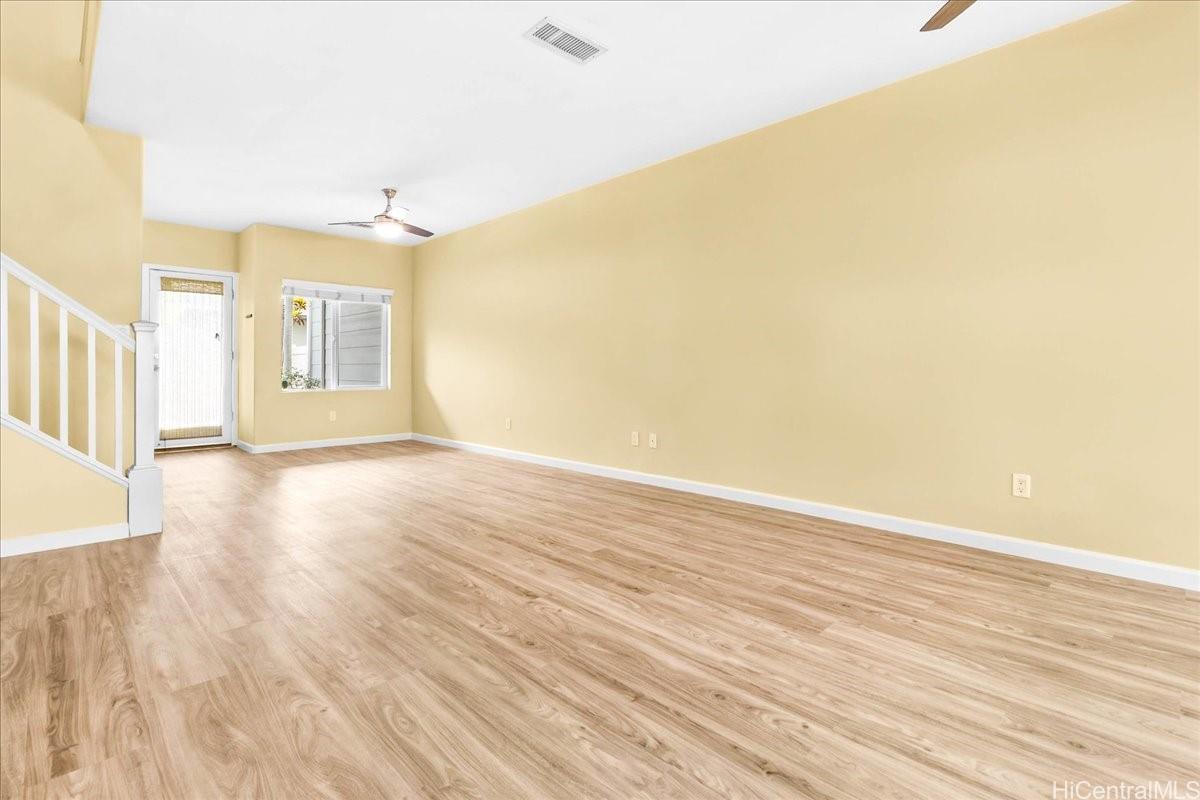 91-1121 Keoneula Boulevard, Unit L5 Ewa Beach, HI 96706 - Photo 3 of 20 a view of a big room with wooden floor and windows