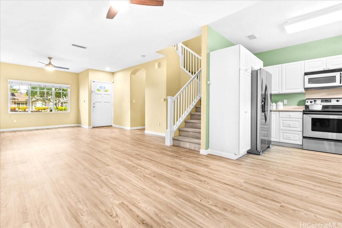 91-1121 Keoneula Boulevard, Unit L5 Ewa Beach, HI 96706 - Photo 5 of 20 a view of a hallway with wooden floor and a living room