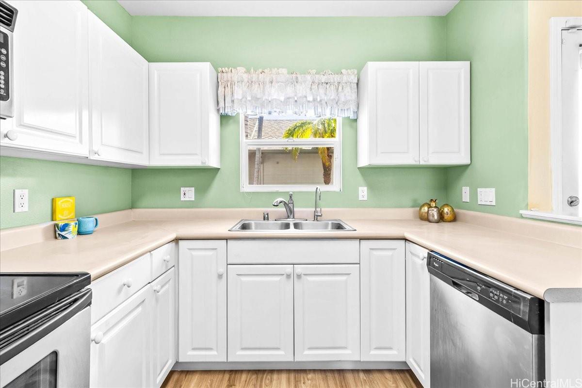 91-1121 Keoneula Boulevard, Unit L5 Ewa Beach, HI 96706 - Photo 6 of 20 a kitchen with cabinets appliances a sink and a window