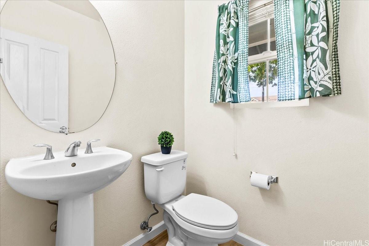 91-1121 Keoneula Boulevard, Unit L5 Ewa Beach, HI 96706 - Photo 9 of 20 a bathroom with a toilet sink and mirror