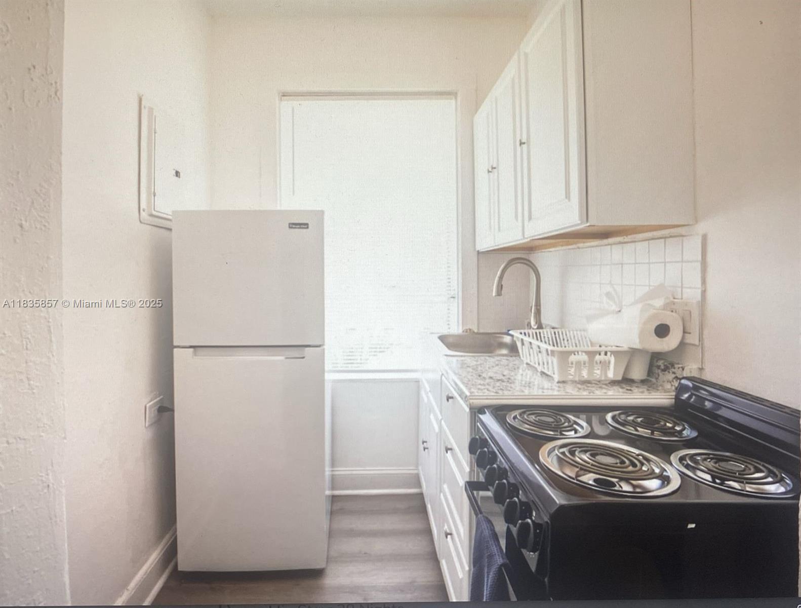 444 Ponce De Leon Boulevard, Unit 12 Coral Gables, FL 33134 - Photo 13 of 14 a kitchen with a stove and a refrigerator