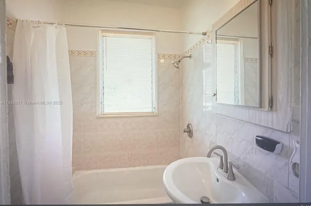 a bathroom with a sink a mirror and a shower