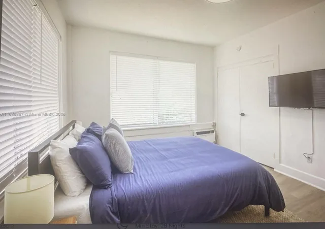 a bedroom with a bed and a flat screen tv