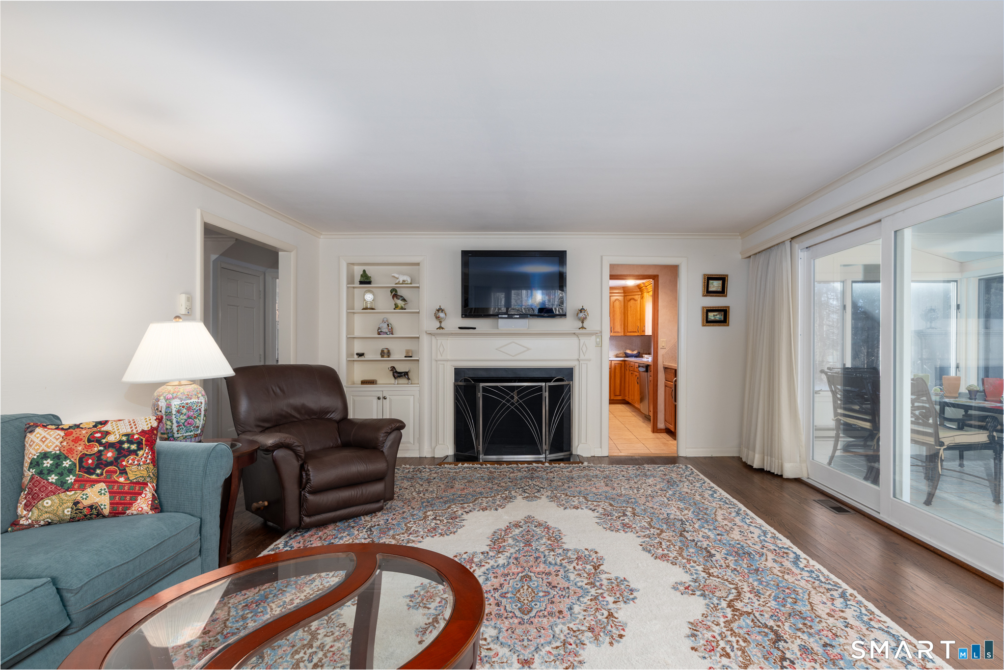 117 Crest Road Middlebury, CT 06762 - Photo 18 of 38 This classic living room has built-ins, a cozy fireplace and warm toned hardwood flooring. It can be open to the sunroom by an oversized sliding door too.