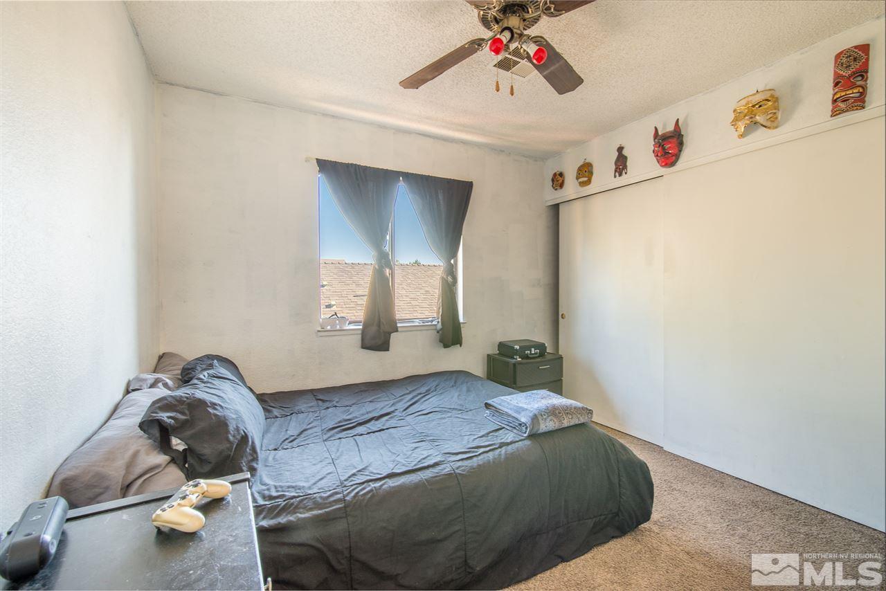5830 Coyote Ridge Road Reno, NV 89523 - Photo 11 of 16 a bedroom with a bed and a chandelier