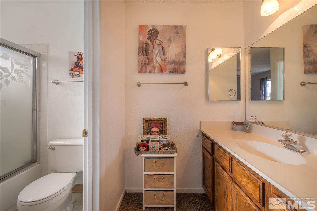 5830 Coyote Ridge Road Reno, NV 89523 - Photo 13 of 16 a bathroom with a sink a toilet and a mirror
