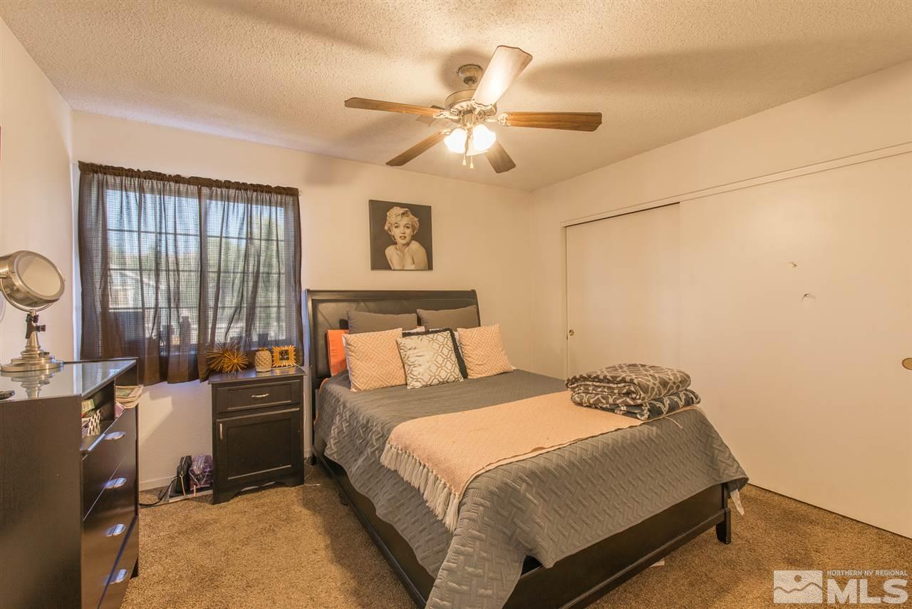 5830 Coyote Ridge Road Reno, NV 89523 - Photo 10 of 16 a bedroom with a bed and wooden floor