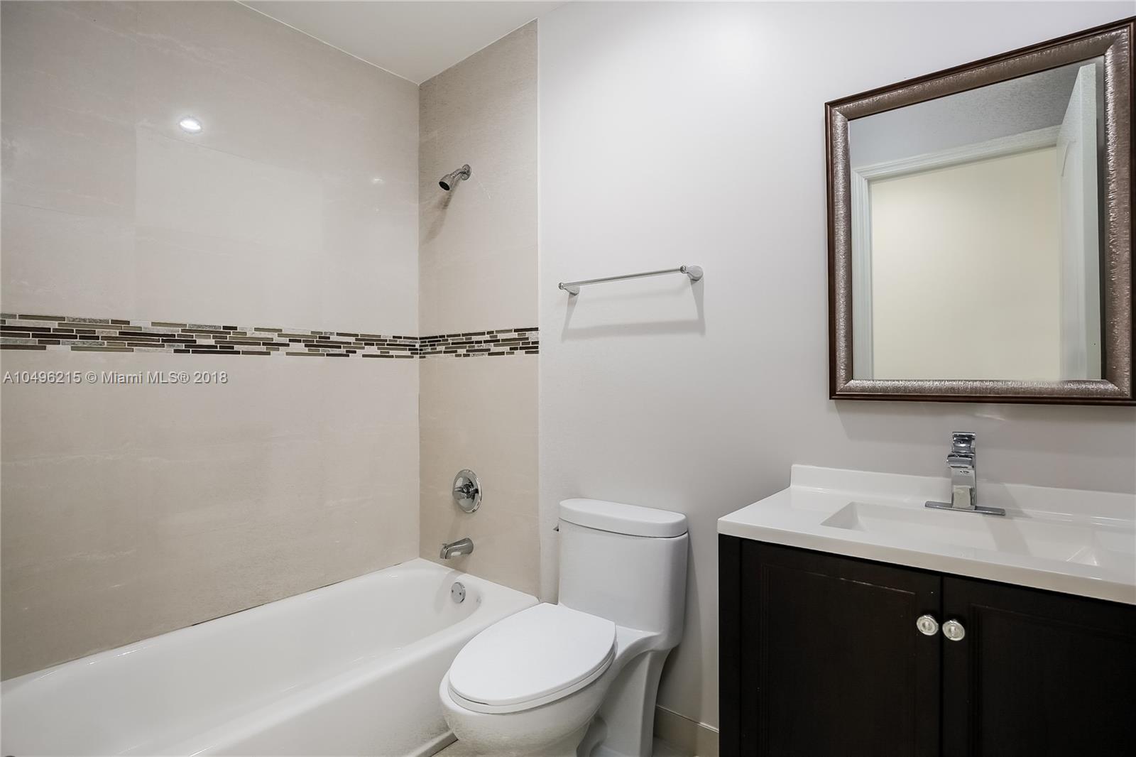 4033 South Le Jeune Road Miami, FL 33146 - Photo 14 of 19 a bathroom with a toilet a sink a mirror and shower