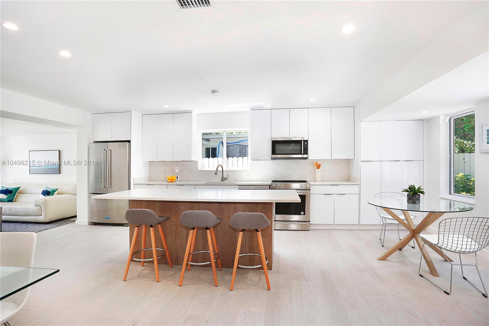 4033 South Le Jeune Road Miami, FL 33146 - Photo 4 of 19 a kitchen with stainless steel appliances a table and chairs in it