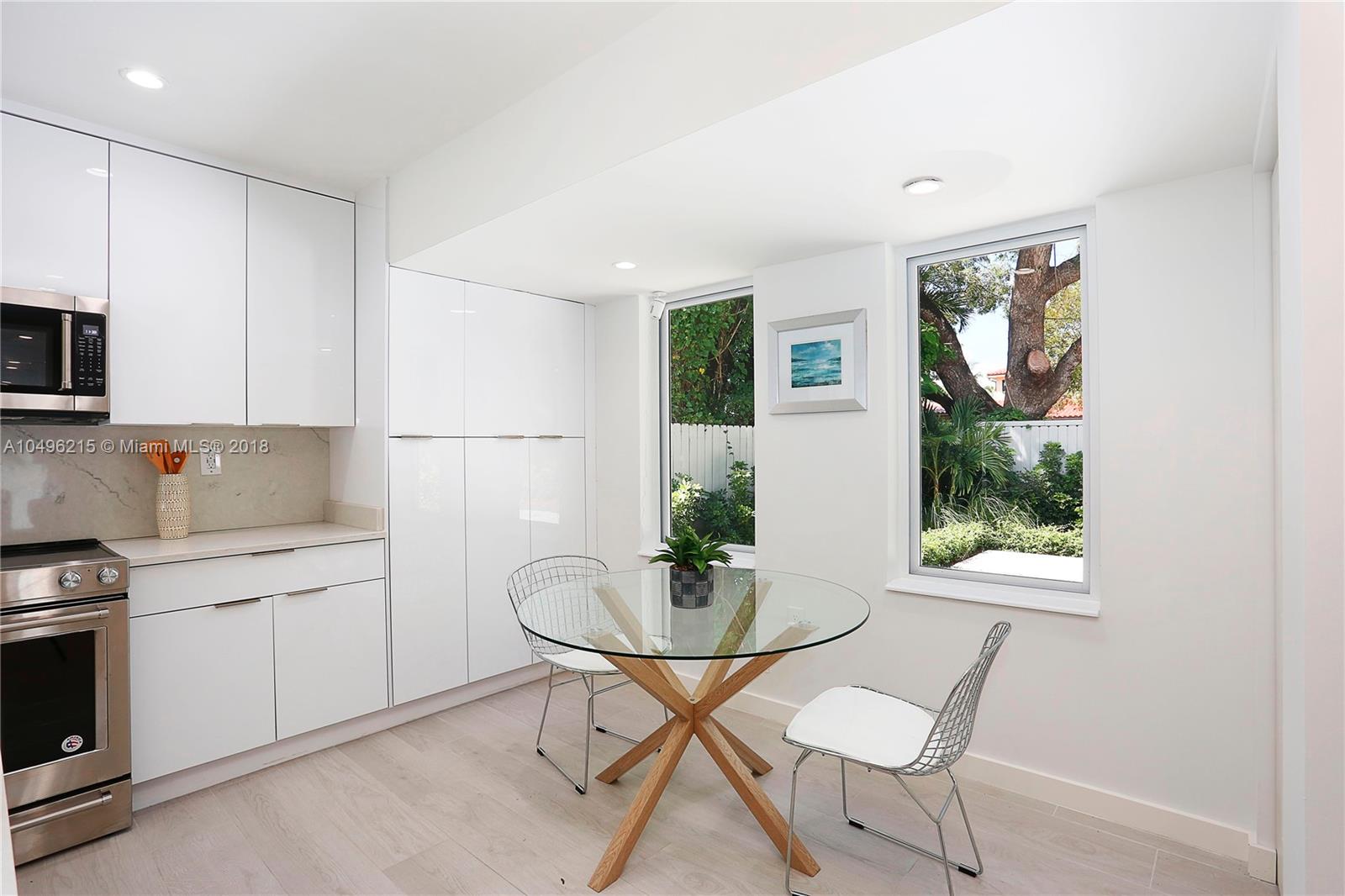4033 South Le Jeune Road Miami, FL 33146 - Photo 6 of 19 a kitchen with stainless steel appliances a dining table chairs and a refrigerator