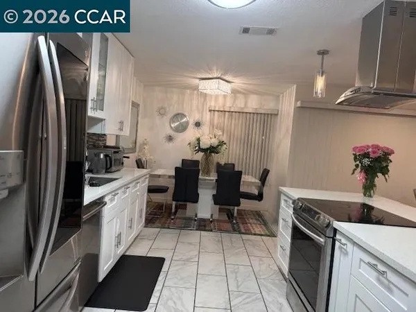 a kitchen with granite countertop a refrigerator a stove a sink a counter space and cabinets