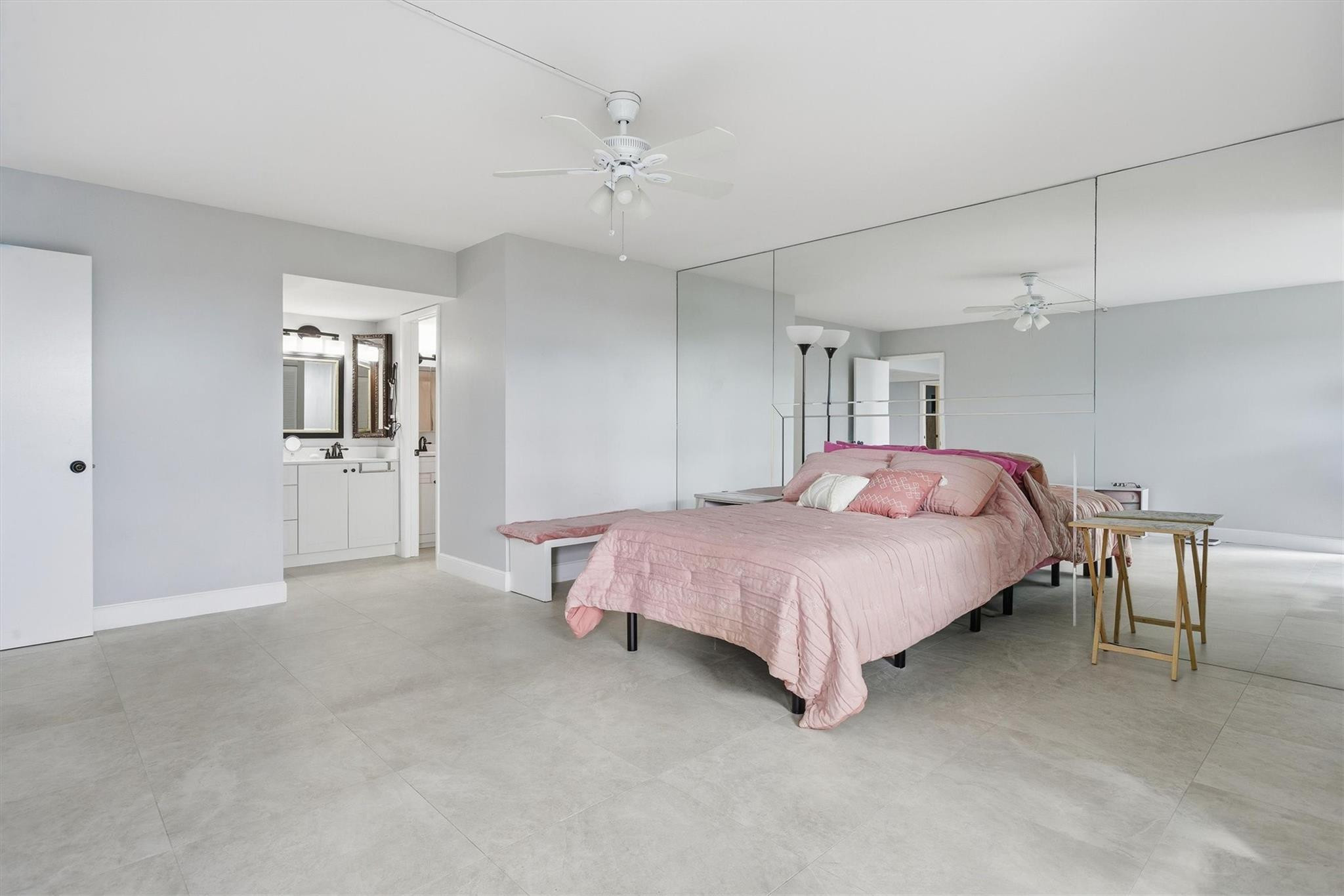 3910 Inverrary Boulevard, Unit 708B Lauderhill, FL 33319 - Photo 19 of 58 a spacious bedroom with a bed and a chandelier