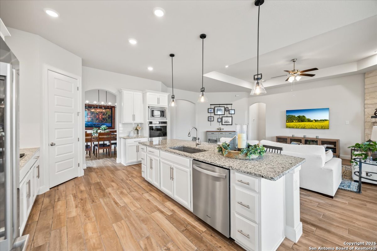 419 Heidelberg Road New Braunfels, TX 78132 - Photo 23 of 62 a kitchen with stainless steel appliances granite countertop a lot of counter space and wooden floors