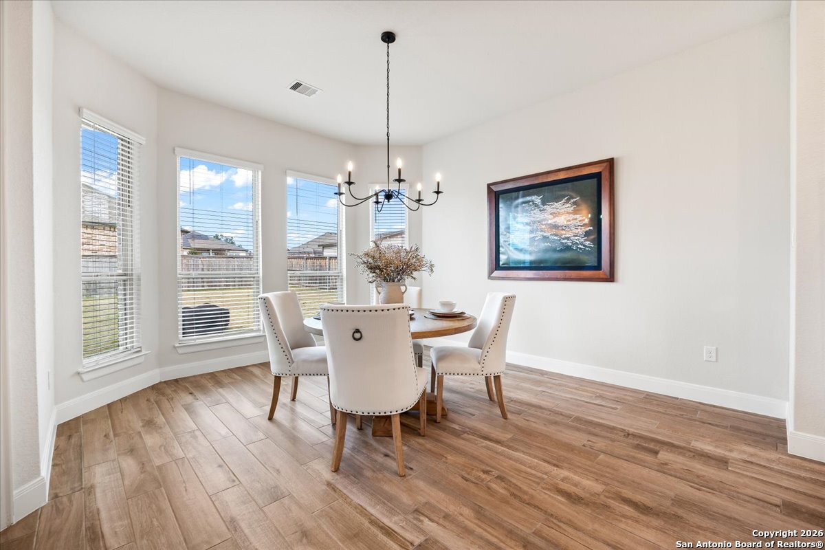419 Heidelberg Road New Braunfels, TX 78132 - Photo 28 of 62 a dining room with furniture a chandelier and wooden floor