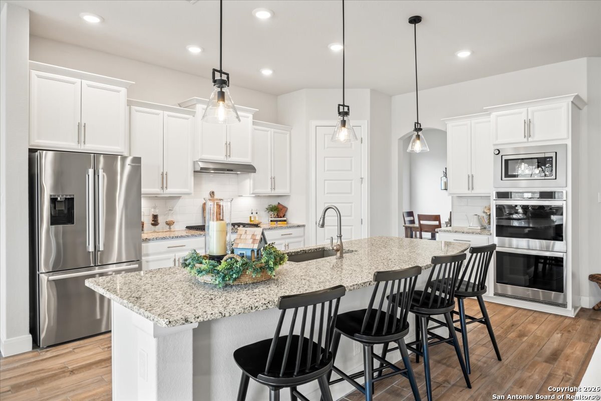 419 Heidelberg Road New Braunfels, TX 78132 - Photo 4 of 62 a kitchen with stainless steel appliances granite countertop a stove a refrigerator a kitchen island a dining table and chairs
