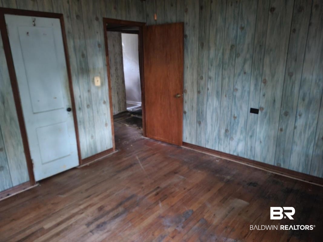 2059 Magnolia Lane Mobile, AL 36605 - Photo 16 of 17 Unfurnished bedroom featuring dark wood-style flooring and baseboards