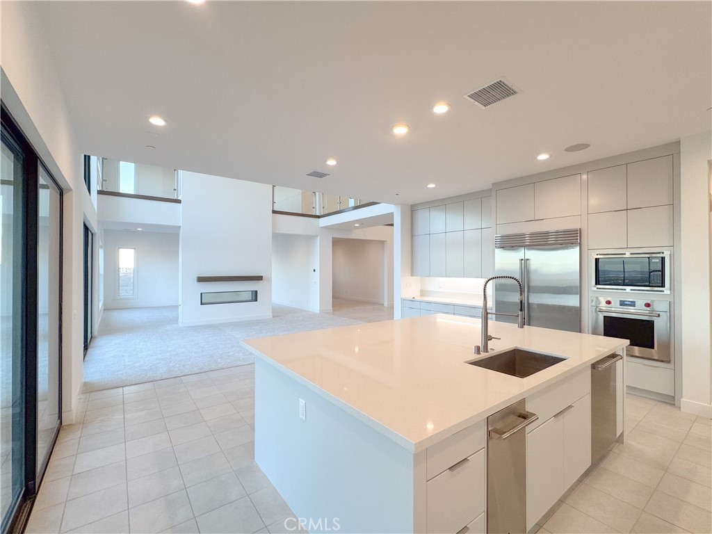 20138 Marlow Lane Porter Ranch, CA 91326 - Photo 12 of 32 a large kitchen with kitchen island a sink a counter top stainless steel appliances and cabinets