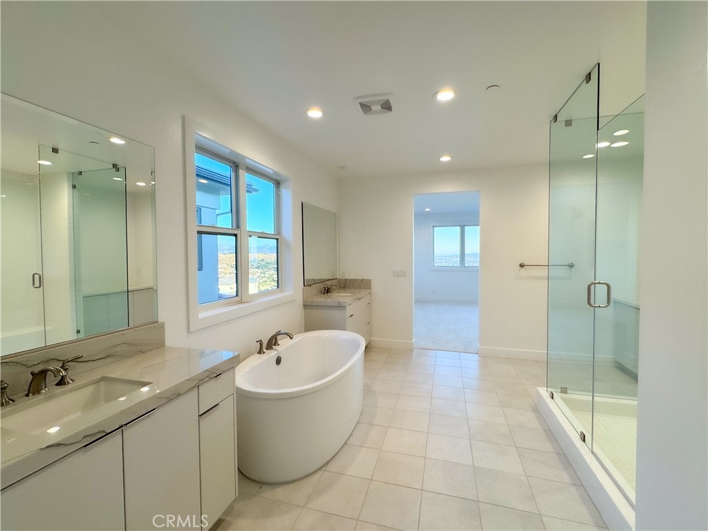 20138 Marlow Lane Porter Ranch, CA 91326 - Photo 23 of 32 a bathroom with a bathtub shower sink and mirror