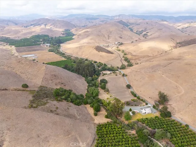 a view of a dry field with mountains in the background