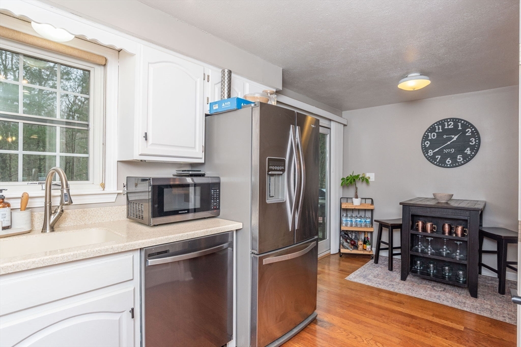 4 Colonial Drive, Unit 4 Norton, MA 02766 - Photo 19 of 34 a kitchen with stainless steel appliances a refrigerator a stove a sink cabinets and a dining table