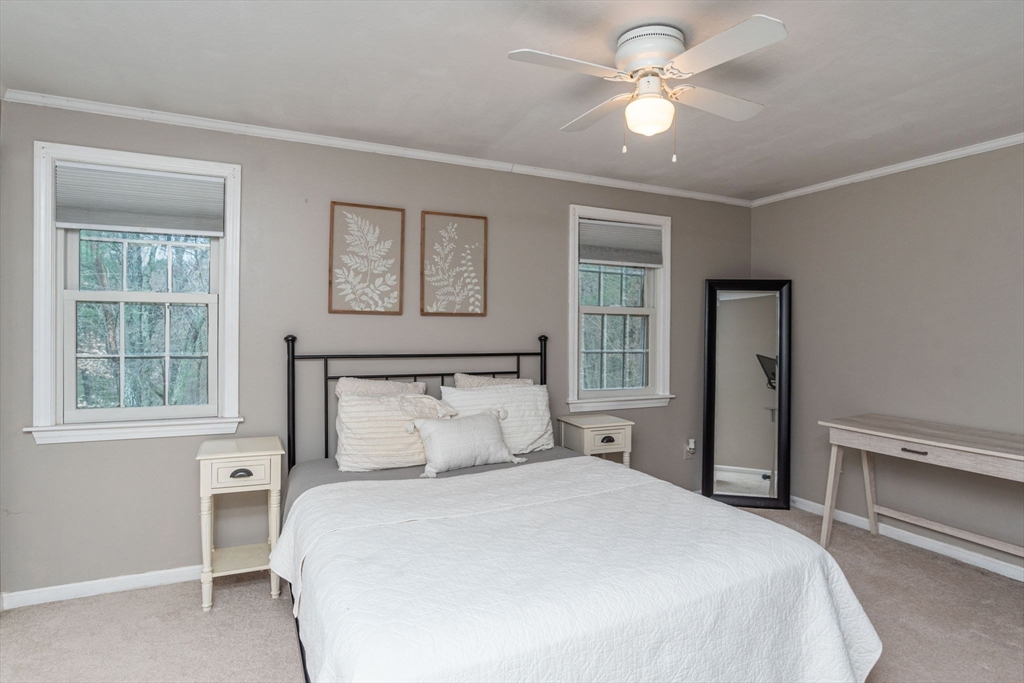 4 Colonial Drive, Unit 4 Norton, MA 02766 - Photo 27 of 34 a bedroom with a bed and a chandelier fan
