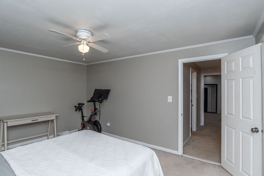4 Colonial Drive, Unit 4 Norton, MA 02766 - Photo 29 of 34 a bedroom with a bed and a chandelier