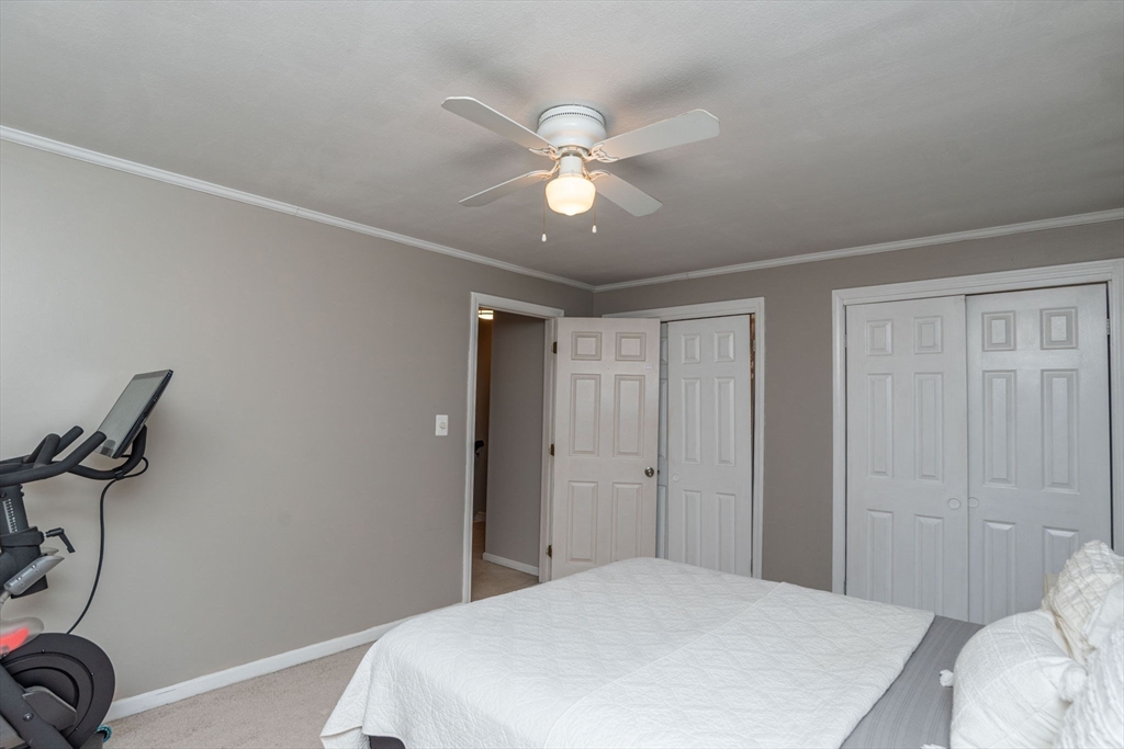 4 Colonial Drive, Unit 4 Norton, MA 02766 - Photo 30 of 34 a bedroom with a bed and a chandelier
