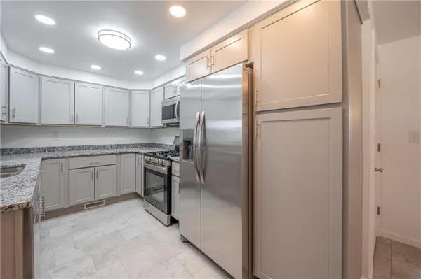 a kitchen with a refrigerator sink and cabinets