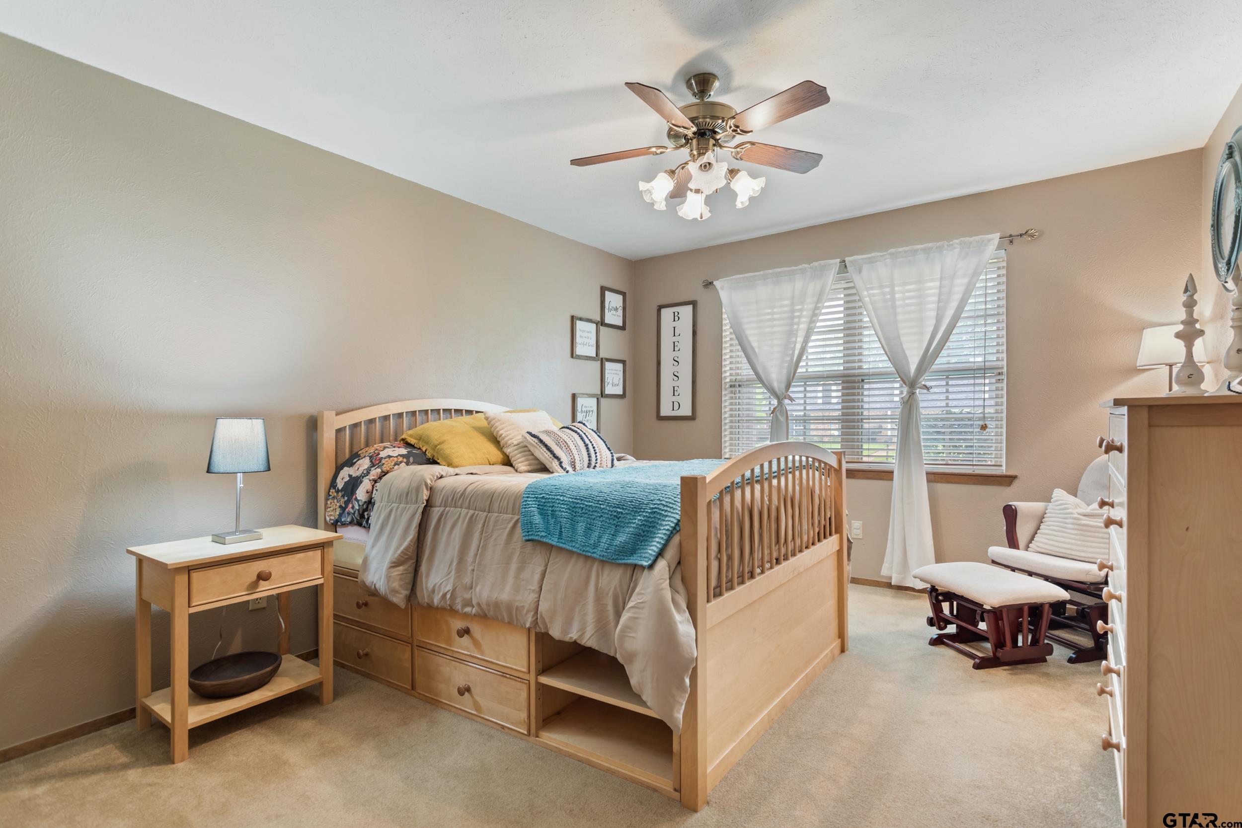 516 Ruthlynn Drive Longview, TX 75605 - Photo 19 of 34 a bedroom with a bed and a chandelier