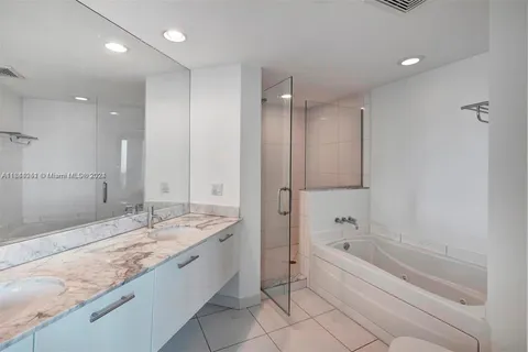 a spacious bathroom with a granite countertop tub sink and mirror